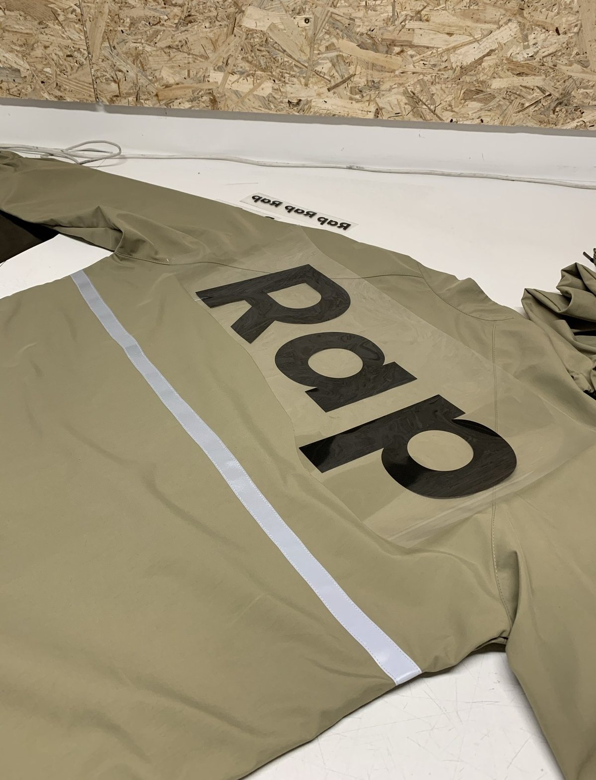 Large Rap wordmark on the back before heat pressing, with a reflective stripe
