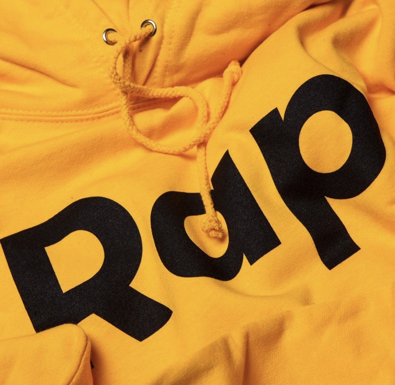 Yellow hoodie with a large Rap wordmark